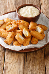 Dutch Kibbeling Deep Fried Battered Fish Pieces with remoulade sauce closeup in the plate on the table. Vertical
