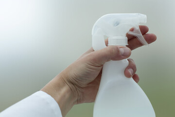 Doctor's hand holding a white spray bottle