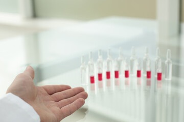 The doctor's hand pointing to the ampoules