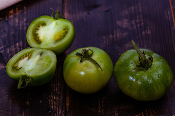 Closeup shot of sliced green tomatoes with knife and napkin on a wooden table