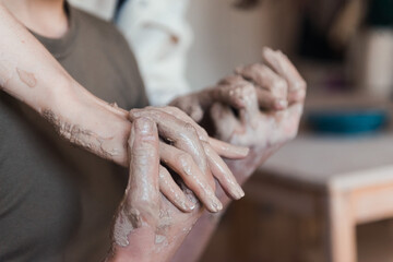 Fototapeta na wymiar loving couple pottery workshop romantic date, hands in natural ckay close-up