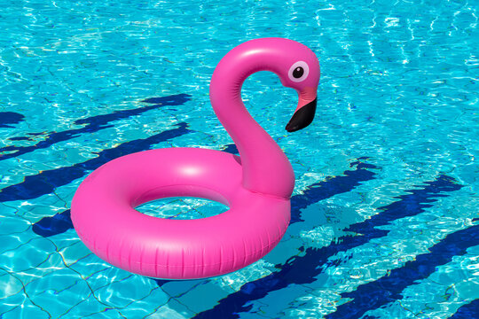 Summer sale. Pink inflatable flamingo in pool water for summer beach background. Minimal summer concept.