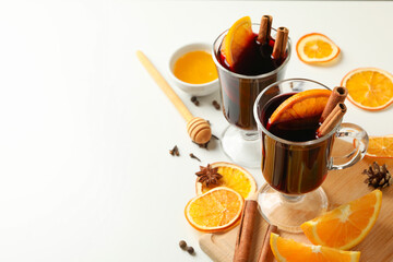 Cups of mulled wine and ingredients on white background