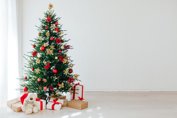 Christmas tree with new year gifts in the white room