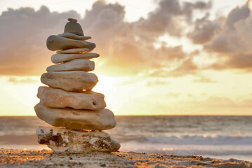 Golden sunset and stacked stones on beach