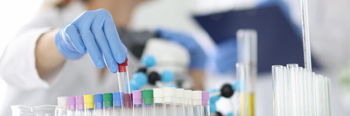 Laboratory diagnostics doctor holds glass test tube in rubber glove closeup. Pcr research on covid 19 concept. © Тихон Купревич