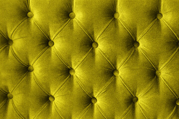 Quilted velour buttoned Illuminating yellow color fabric wall pattern background. Elegant vintage...