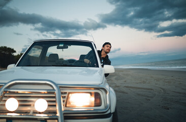 Fototapeta na wymiar Ragazzo viaggia in macchina sulla spiaggia
