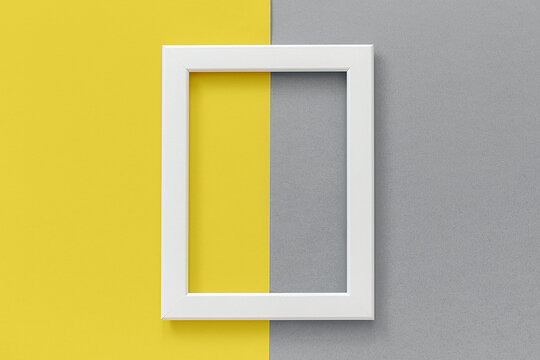 White Frame On Yellow And Gray Background. Creative Flat Lay Top View Mockup Copy Space For Text. Trendy Colors 2021.