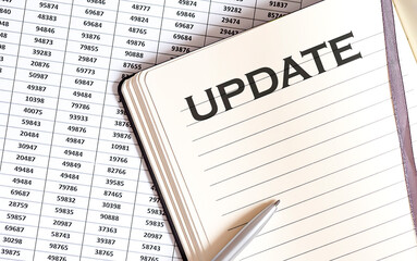 Obraz premium Business concept, on the table a notepad with the text of the UPDATE , profit, loss and graph