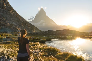 Fotobehang Woman enjoying the view at the famous Matterhorn from the Riffelsee. © sanderstock