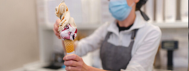 Horizontal banner Close-up unrecognizable woman handling and preparing an ice-cream in the store...