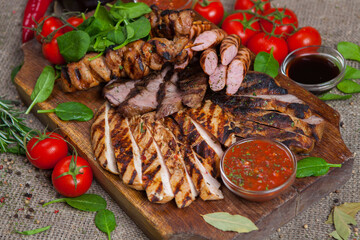 Mixed grilled meat platter. Assorted delicious grilled meat with vegetable. Mixed grilled meat with pepper sauce and vegetables.