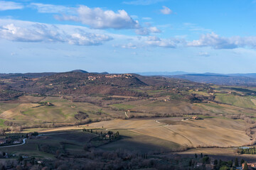 Picturesque winter landscape view of Tuscany with stone houses, colorful hills, fields and vineyards in Italy.