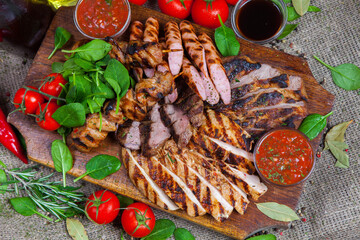 Mixed grilled meat platter. Assorted delicious grilled meat with vegetable. Mixed grilled meat with pepper sauce and vegetables.
