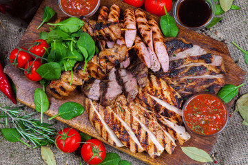 Mixed grilled meat platter. Assorted delicious grilled meat with vegetable. Mixed grilled meat with pepper sauce and vegetables.