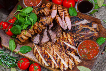Mixed grilled meat platter. Assorted delicious grilled meat with vegetable. Mixed grilled meat with pepper sauce and vegetables.