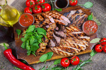 Mixed grilled meat platter. Assorted delicious grilled meat with vegetable. Mixed grilled meat with pepper sauce and vegetables.