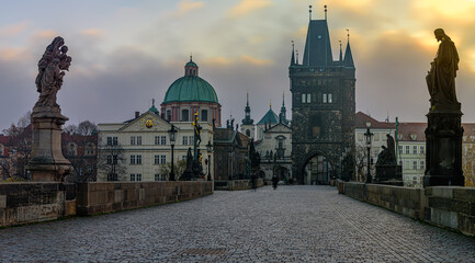 Fototapeta na wymiar A mysterious autumn dawn at Charles Bridge covered in thick mist in historical center of Prague.