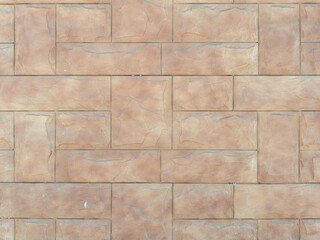 Beige wall with embossed rectangular tiles lined with pattern. Background texture