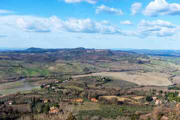 Obraz premium Picturesque winter landscape view of Tuscany with stone houses, colorful hills, fields and vineyards in Italy.