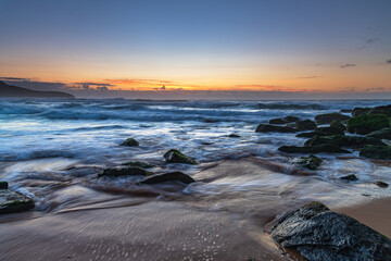 Fototapeta premium Sunrise seascape with light cloud, waves and rocks