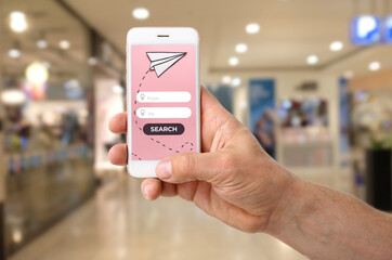 Man with mobile phone booking flight tickets online, closeup