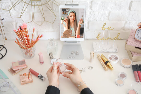 Subscriber at table watching channel of professional beauty blogger