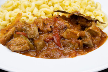 morceaux de porc cuisiné à la sauce tomate et pâtes
