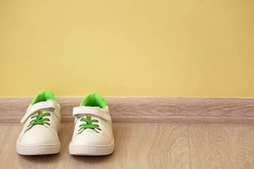 Child's shoes near color wall