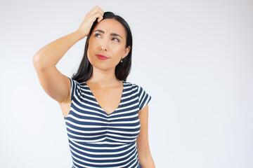 Young beautiful woman wearing striped t-shirt over white isolated background confuse and wondering about question. Uncertain with doubt, thinking with hand on face. Pensive concept.