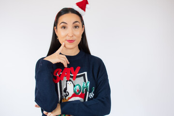 Fototapeta premium Young beautiful woman wearing santa hat over white isolated background confuse and wondering about question. Uncertain with doubt, thinking with hand on face. Pensive concept.