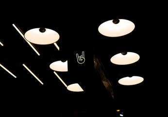 Underexposed photography of some spotlights and lights. Among them there is a luminous one with a...