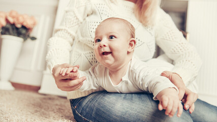 Fototapeta premium mother with baby sitting near the fireplace in a cozy living room