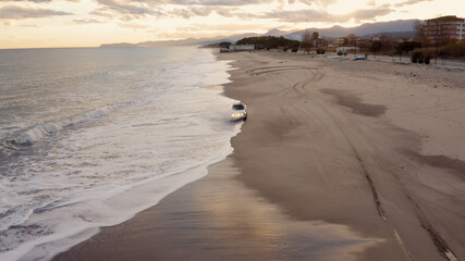 Macchina corre veloce sulla sabbia e si infrange nel mare