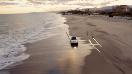 Macchina fuoristrada bianca che corre nella spiaggia vicino l'oceano