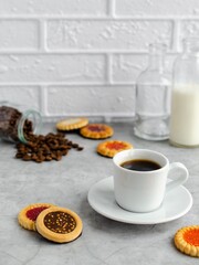 Coffee in a cup, coffee beans, gingerbread on the table. Tasty food.