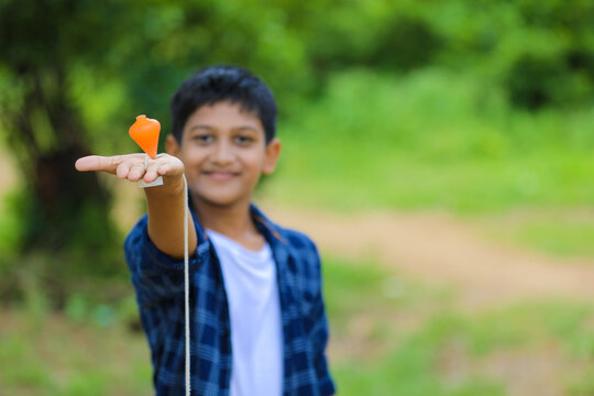 Cute indian little child playing Lattu, Bhovra or Bambaram is a traditional throwing top using thread, played mainly in India