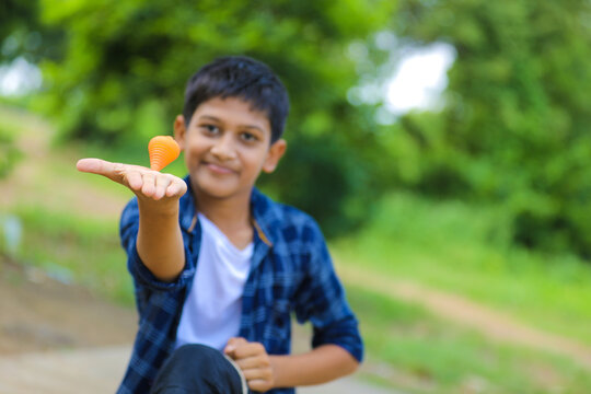 Cute indian little child playing Lattu, Bhovra or Bambaram is a traditional throwing top using thread, played mainly in India