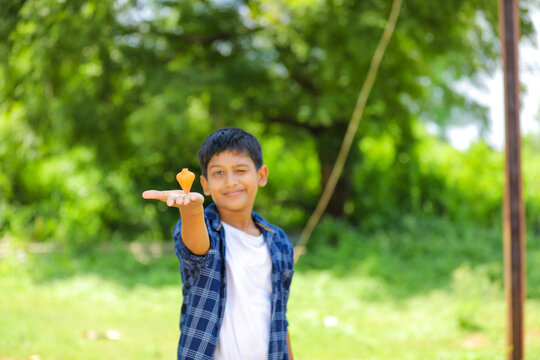 Cute indian little child playing Lattu, Bhovra or Bambaram is a traditional throwing top using thread, played mainly in India