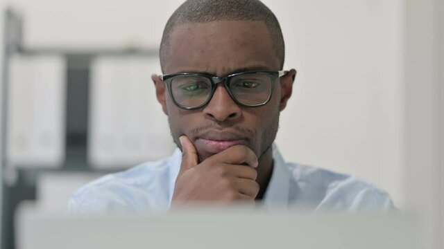 Close Up of Pensive African Man Using Laptop, Thinking