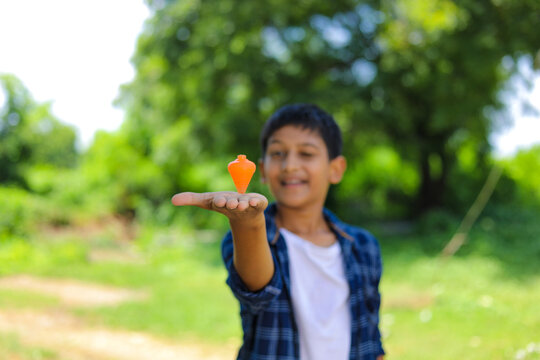 Cute indian little child playing Lattu, Bhovra or Bambaram is a traditional throwing top using thread, played mainly in India