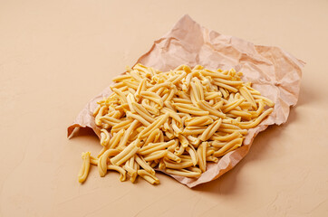 Yellow dry pasta on parchment paper