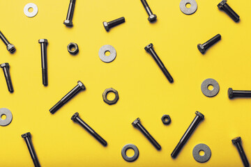 Bolts and nuts closeup on yellow background.