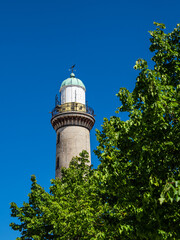Blick auf den Leuchtturm mit Baum in Warnemünde