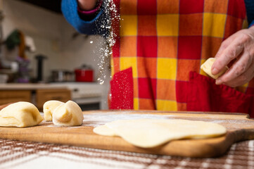 Woman preparing dough for  manti  with minced beef meat