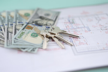 Dollar bills and keys lying on plan of apartment closeup