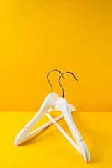 White hangers on a yellow background. Sales clothes concept.