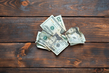 Crumpled banknotes on a wooden background. Crumpled dollars studio image.
