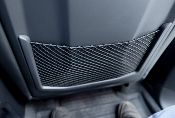 Pocket behind the seat in the car interior, made in the form of a grid.